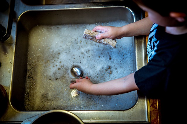 Anak mencuci piring sendiri secara mandiri.